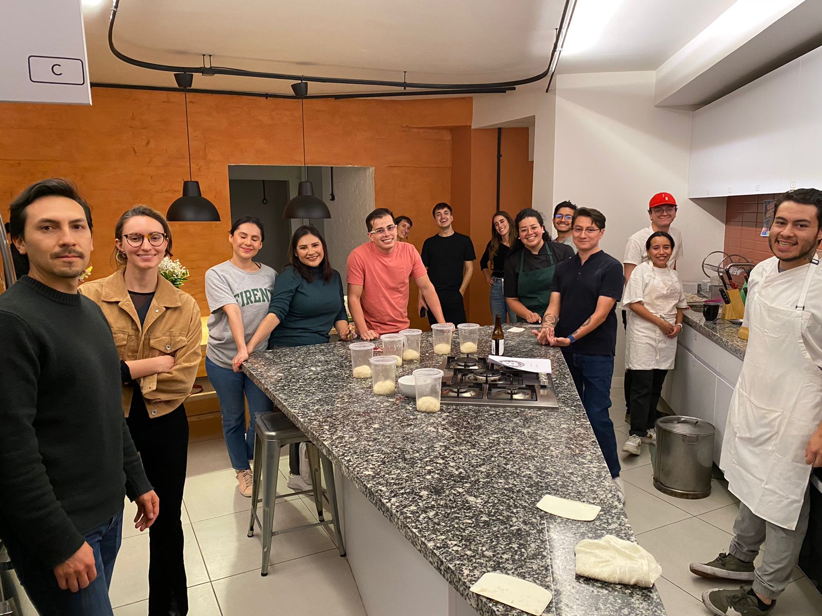 Grupo de jóvenes cocinando y conviviendo en la cocina de un coliving en la CDMX.